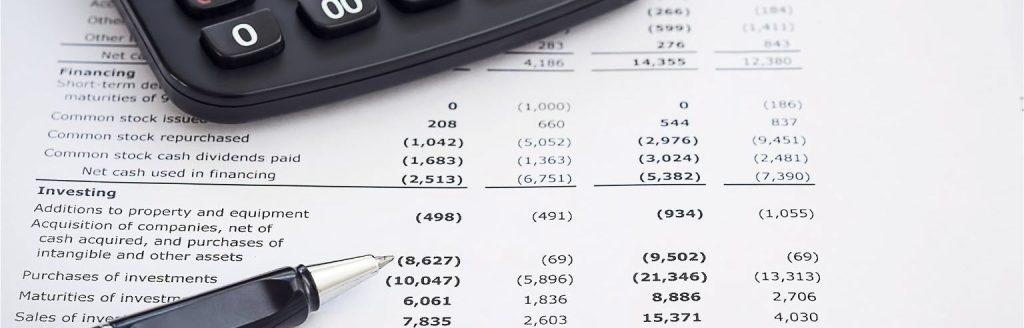 Close-up of financial records and a calculator pen, representing the investigation of misappropriated corporate assets and director fraud in Ontario and BC