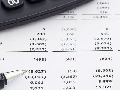 Close-up of financial records and a calculator pen, representing the investigation of misappropriated corporate assets and director fraud in Ontario and BC