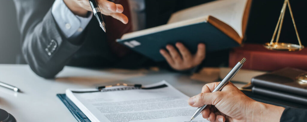 Close-up of a lawyer gesturing during a client consultation while reviewing a legal text, representing the consideration of an appeal or judicial review in ontario