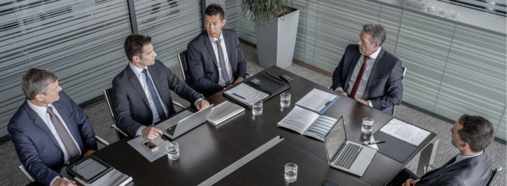 Executives seated around a boardroom table in a corporate meeting, representing directors' and officers' duties and personal liability risks under Ontario corporate law