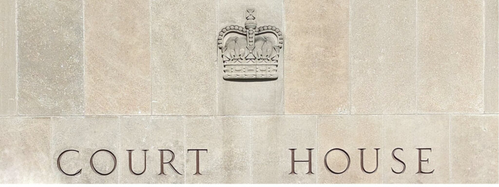 Close-up of the engraved crown and "Court House" inscription on the facade of 361 University Avenue in Toronto, representing judicial review and appellate proceedings in Ontario
